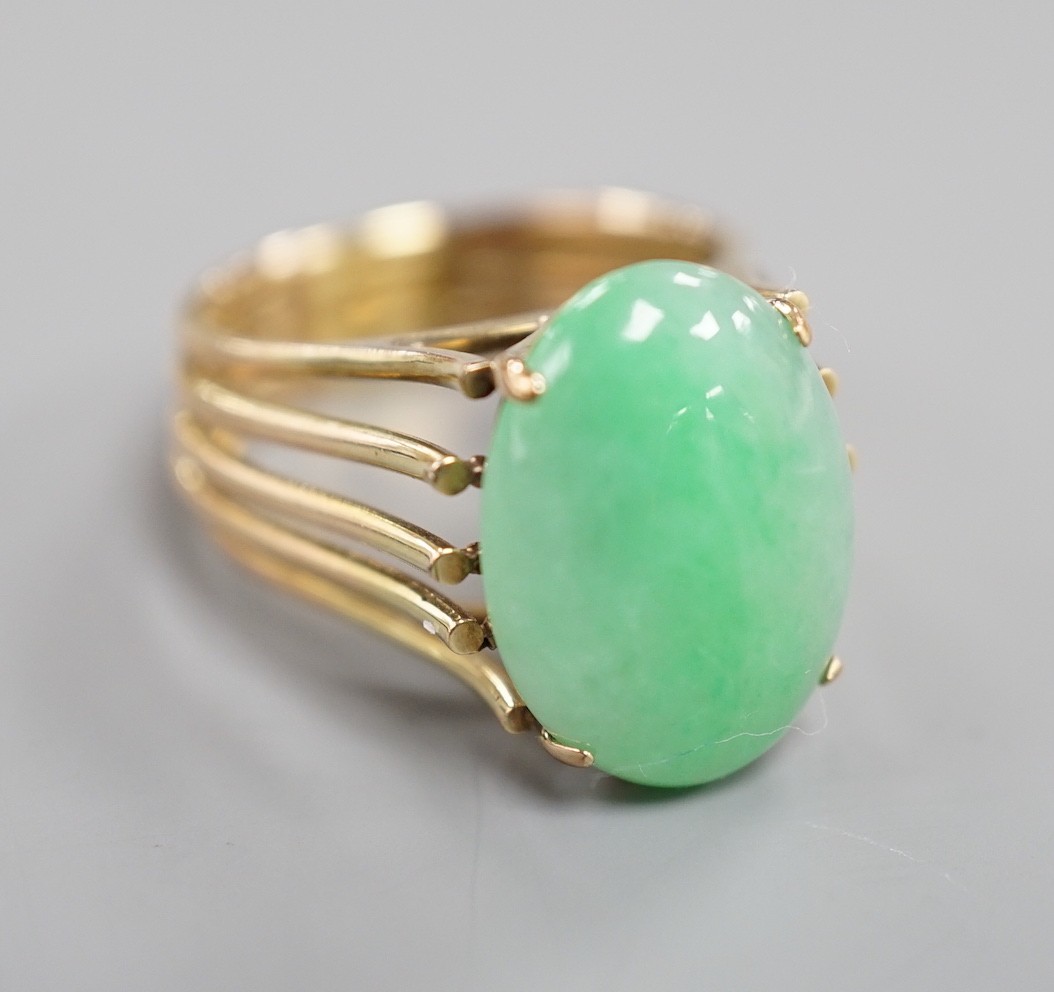 A 585 yellow metal and cabochon jade set oval dress ring, size P/Q, gross weight 8.4 grams.